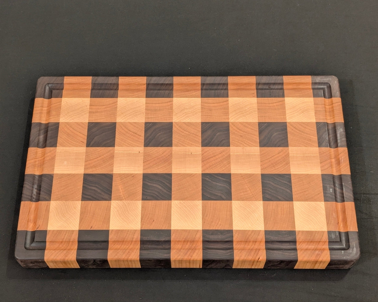 Wooden cutting board with a checkered pattern on a black background