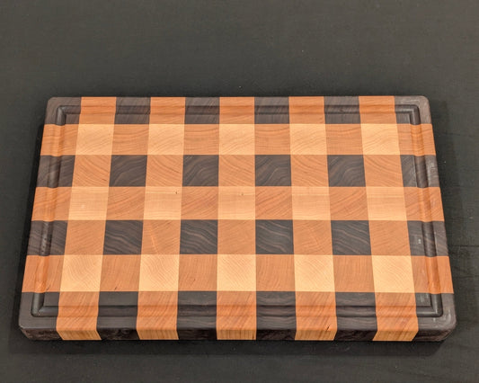 Wooden cutting board with a checkered pattern on a black background